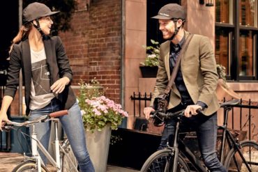 Eine Frau und ein Mann sitzen auf Fahrrädern und tragen den Fahrradhelm von Park & Diamond