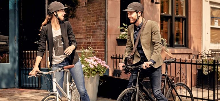 Eine Frau und ein Mann sitzen auf Fahrrädern und tragen den Fahrradhelm von Park & Diamond