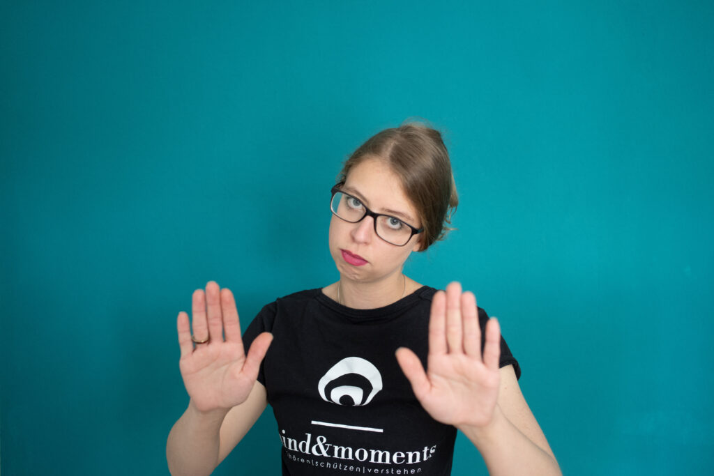 mindandmoments: Die Gründerin zeigt eine Abwehrbewegung mit den Händen um einen Konflikt zu symbolisieren.