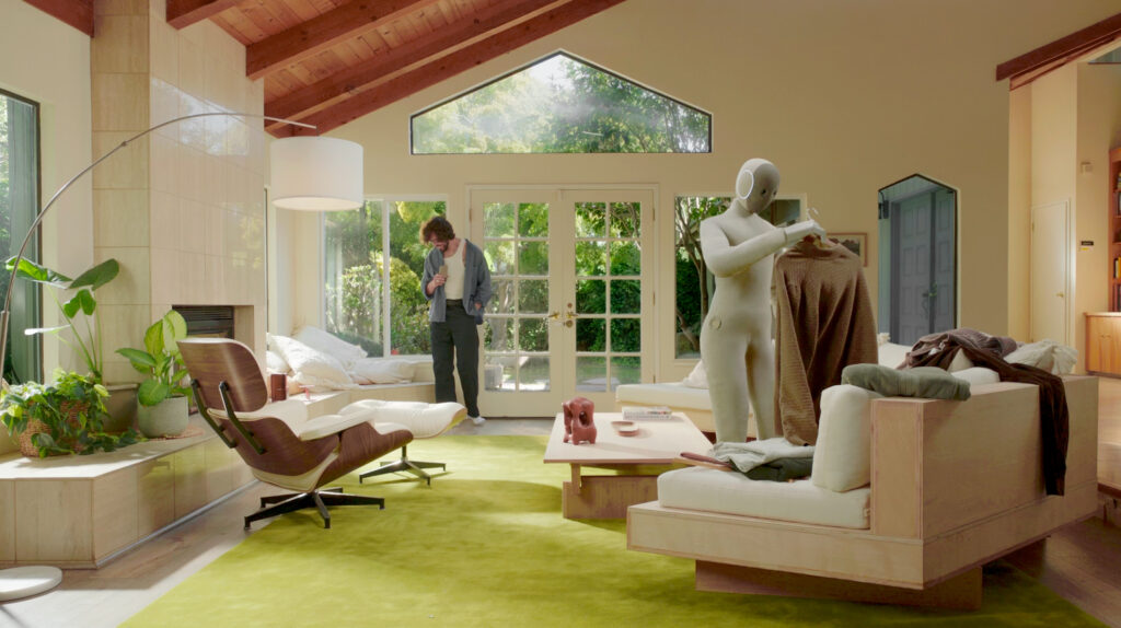 NEO Roboter im Aktion (Ein Roboter hängt Wäsche auf und steht im Wohnzimmer)